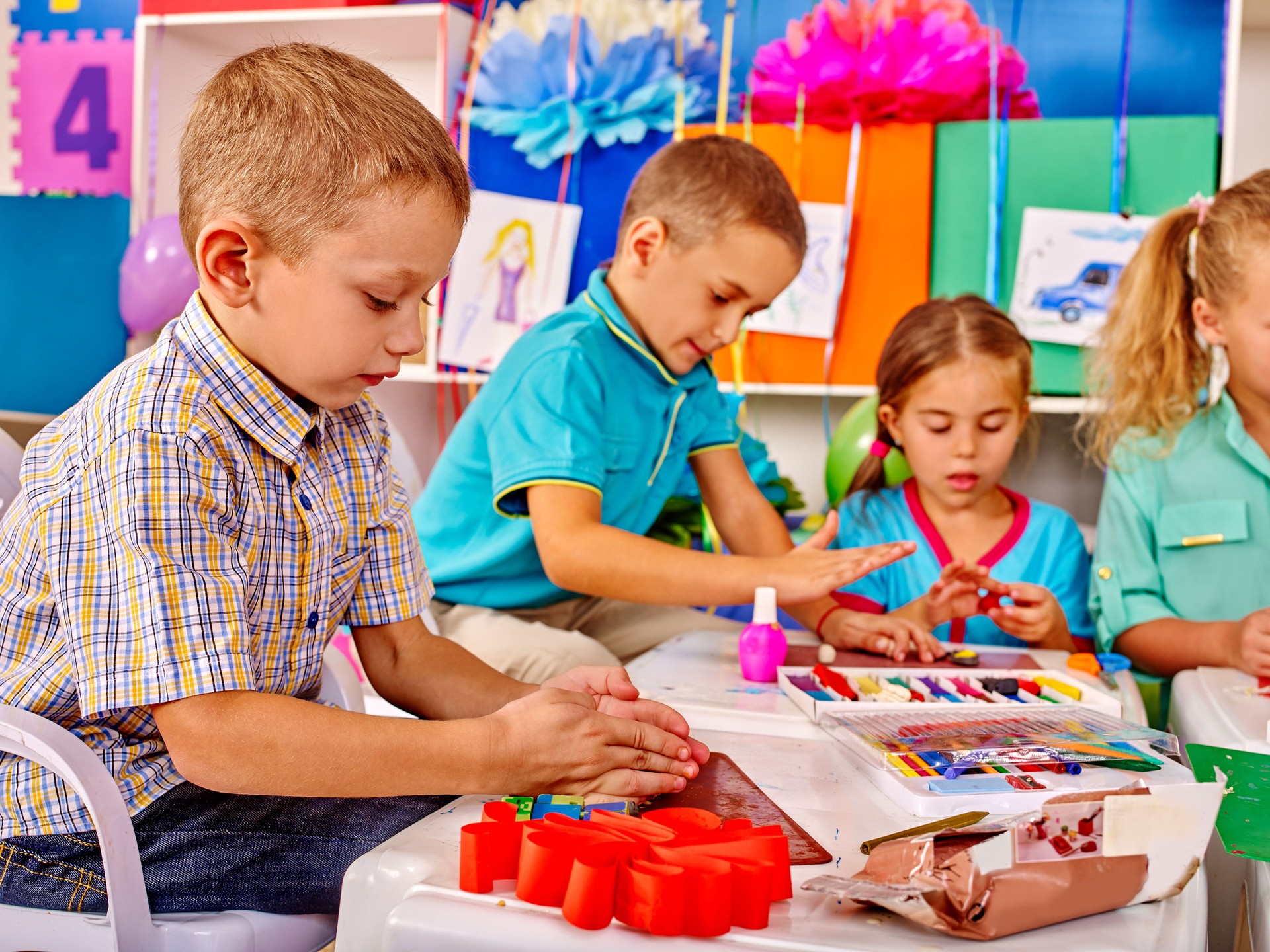 Kinder halten bunte Papier und Stoff auf Tisch in bereits im kindergarten