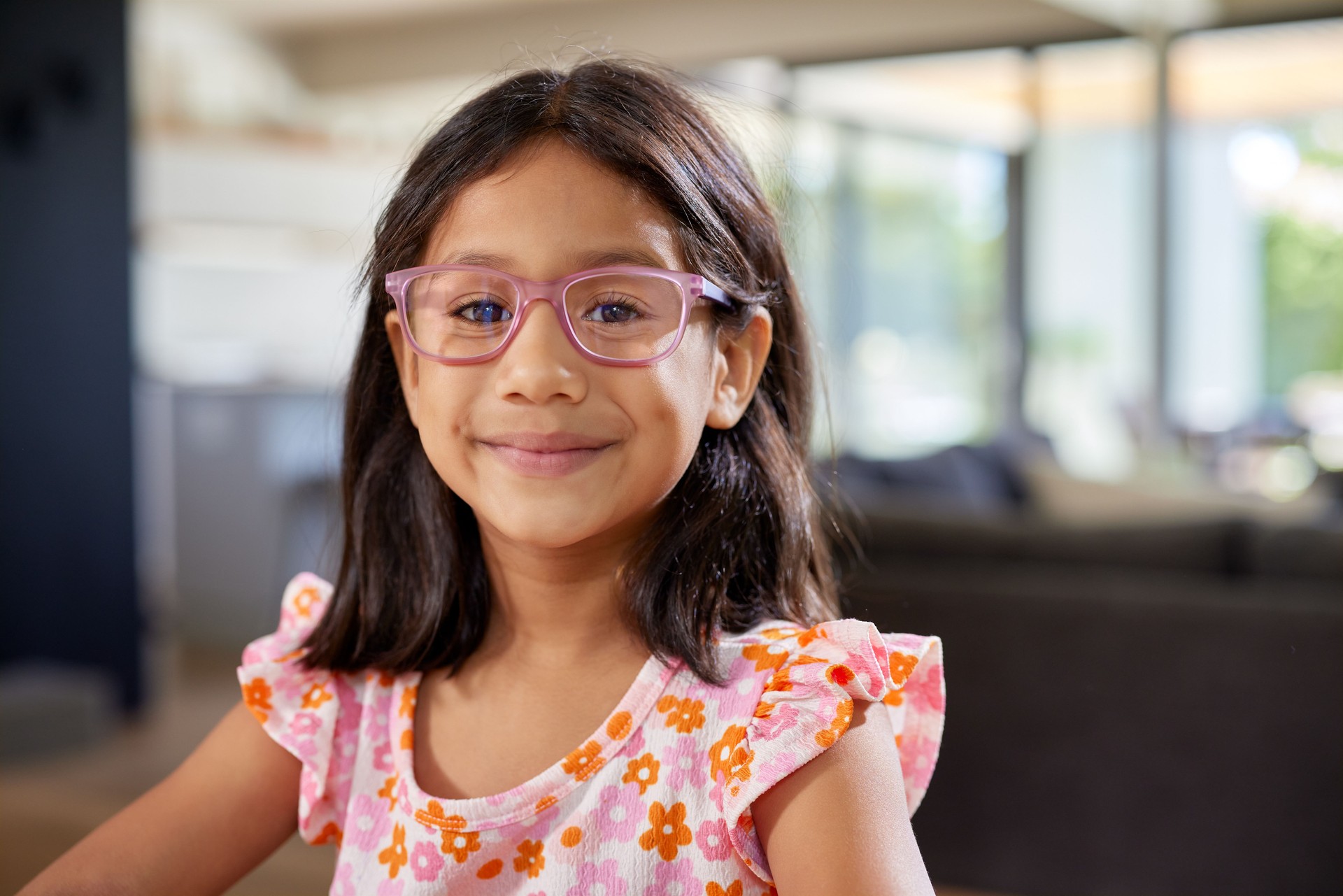 Indisches süßes kleines Mädchen, das lächelt, während es eine Brille trägt