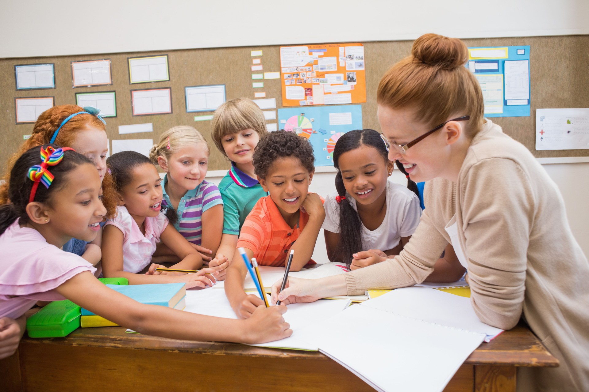 Lehrer und Schüler Arbeiten am Schreibtisch zusammen